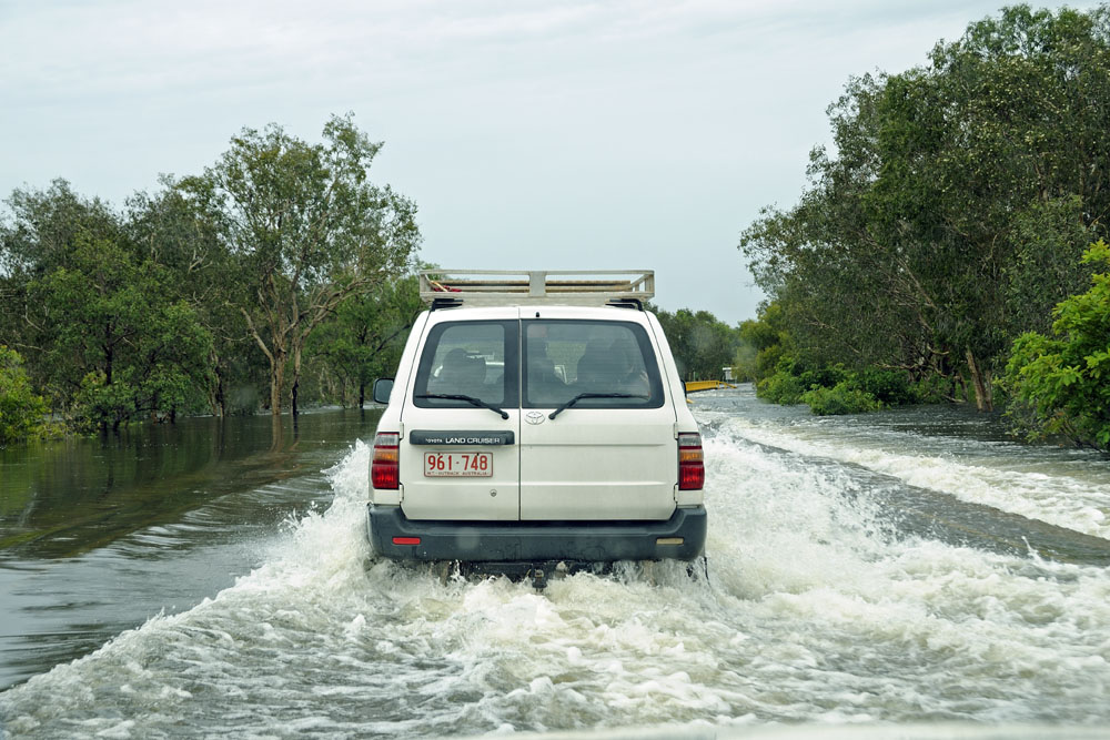 Water rushing across flooded road