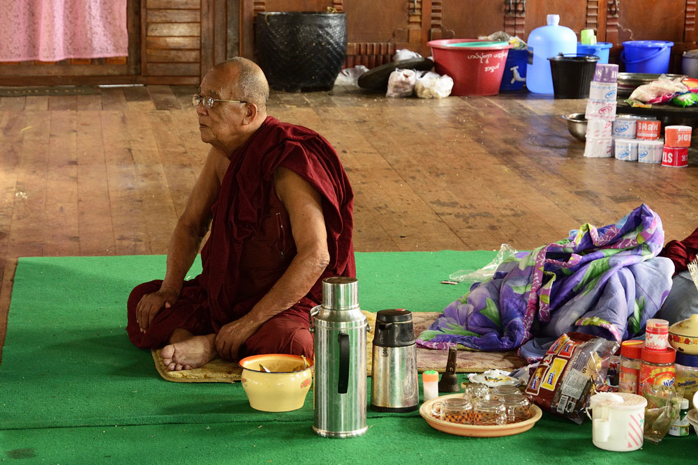 Monk inside monastery watching boxing match on TV