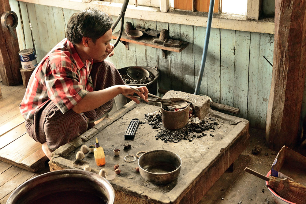 Melting silver using hot coals at silversmith