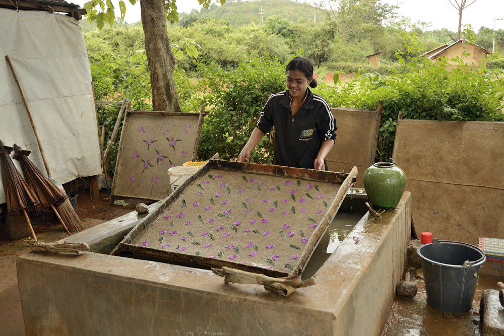 Lifting a sheet of decorated paper on drying rack