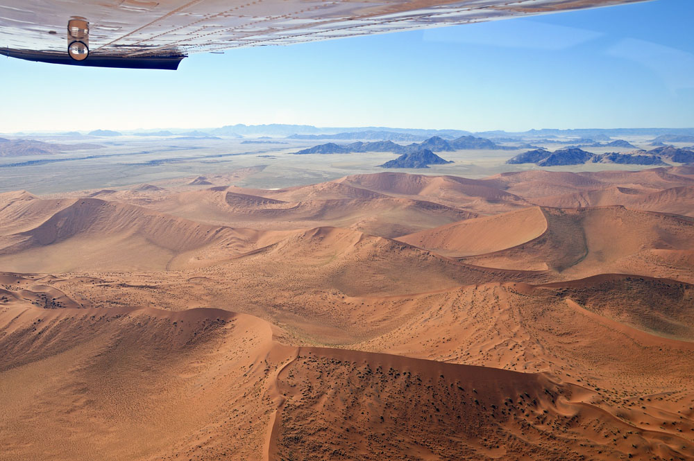 Mountains and grass filled valleys transition to sand dunes