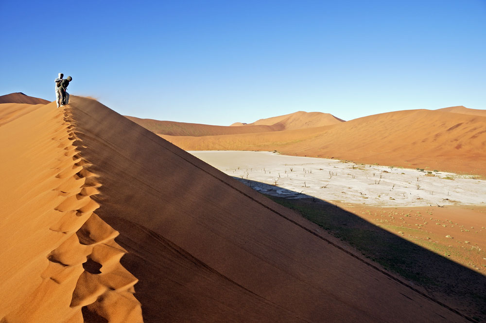 Hiking up windy sand dune overlooking Dead Vlei